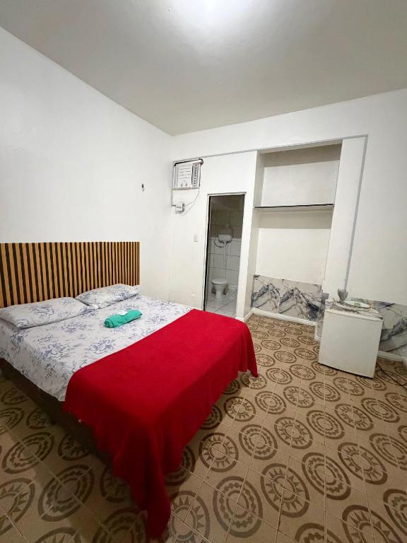 a bedroom with a bed with a red blanket on it at Quarto no centro 207 in Manaus