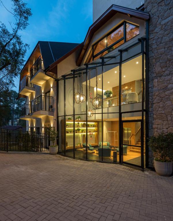 a house with large glass windows in front of it at Villa Amistà Campos do Jordão in Campos do Jordão