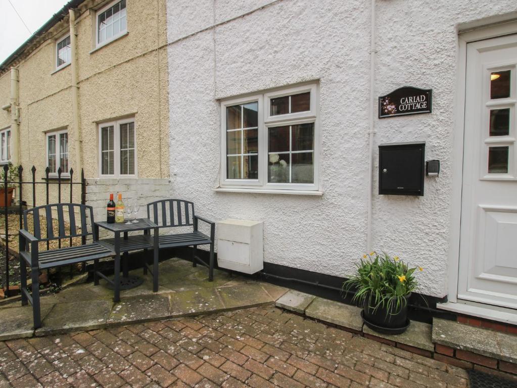 a table and two benches outside of a building at Cariad Cottage in Ludlow