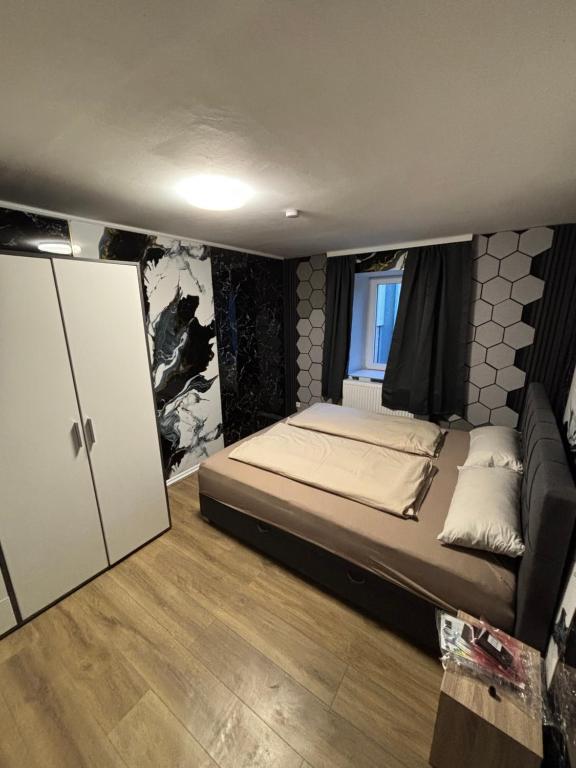 a small bedroom with a bed and a window at Haus am Freilinger See Bar in Blankenheim
