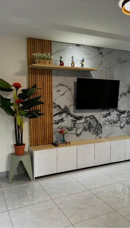 a living room with a flat screen tv on a wall at Oasis de Moanda 1 in Libreville
