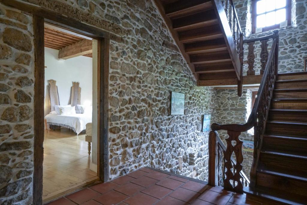 a stone house with a staircase and a bedroom at Le Presbytère de Bugarach in Bugarach
