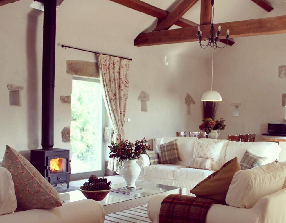 a living room with white furniture and a fireplace at Winnow Barns Holidays in Ashbourne