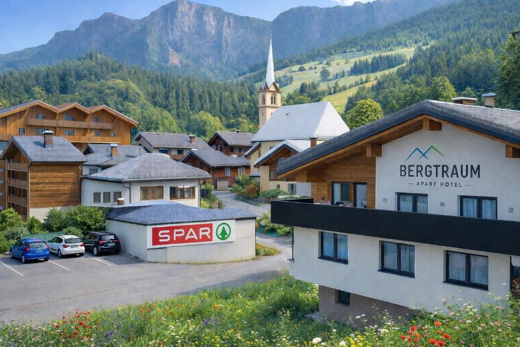 a small town with a church and a parking lot at Aparthotel Bergtraum in Mühlbach am Hochkönig