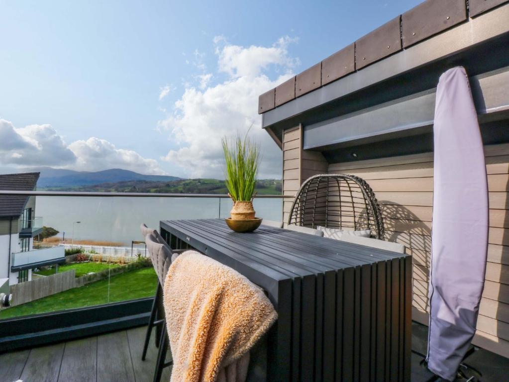 a table on a balcony with a view of the water at 2 Glan Yr Aber in Colwyn Bay