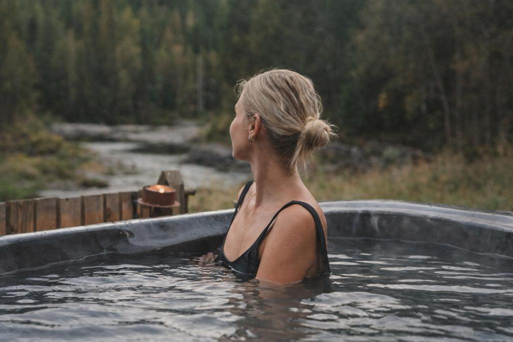 a woman is sitting in a bath tub at Ådalsvollen Retreat -Go Wild for a While, Private Nature Getaway in Verdal