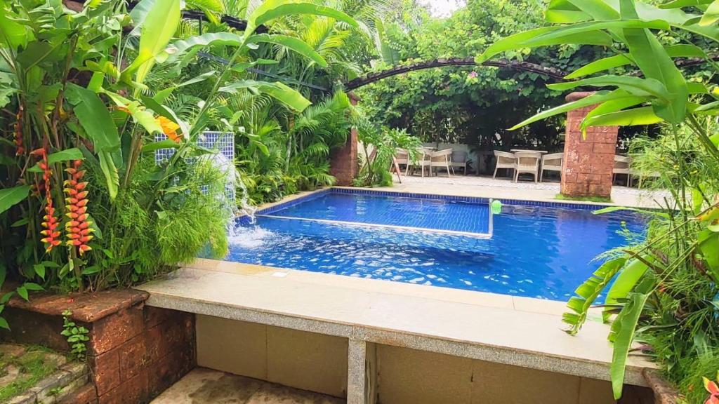 a swimming pool in a garden with plants at 4 BHK villa with private Jacuzzi & Shared pool- Anjuna in Anjuna
