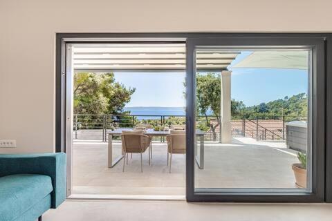 a living room with a sliding glass door to a patio at Sea View House with Jacuzzi - Casa Bianca Brač in Selca