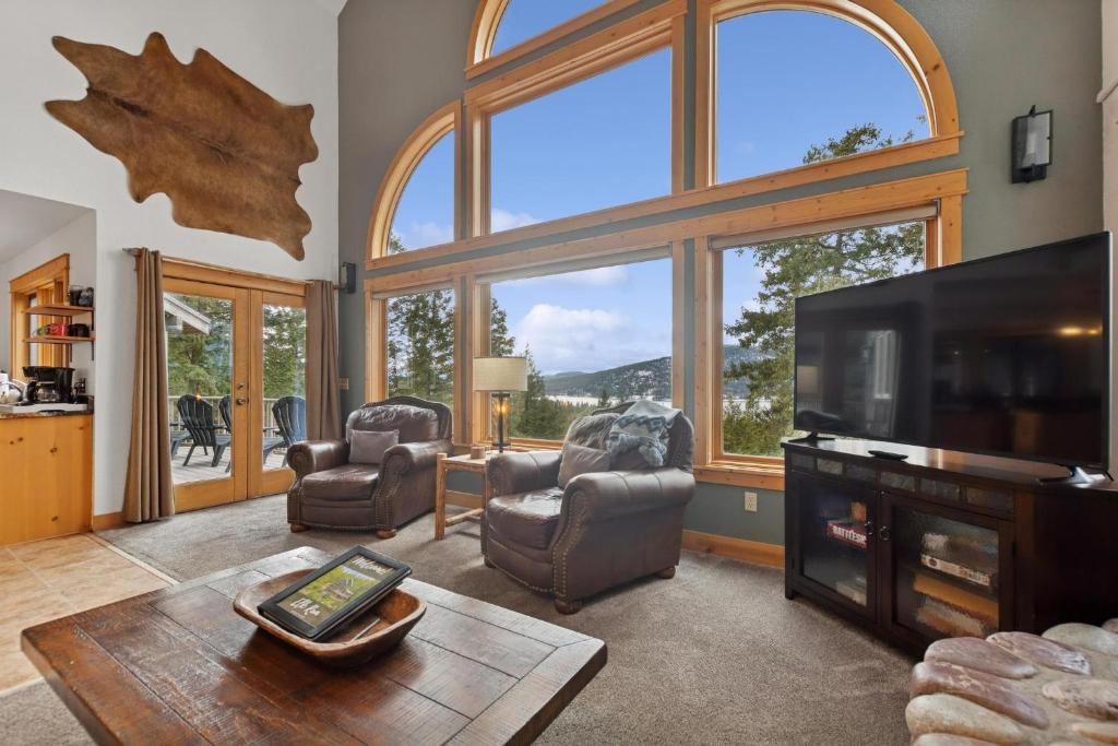 a living room with a large window and a tv at Elk Run in Whitefish