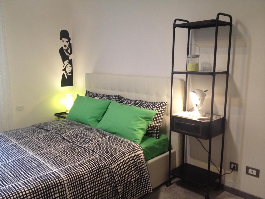 een slaapkamer met een bed met groene kussens en een plank bij Decorialab Apartments in Bologna