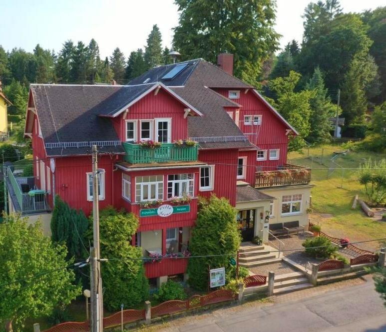 a large red house with a black roof at Pension Villa Irene in Kurort Gohrisch