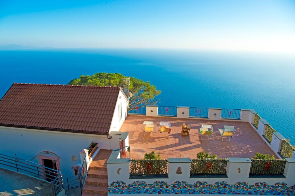 - une vue sur une maison avec une terrasse et l'océan dans l'établissement Residence Calipso, à Furore