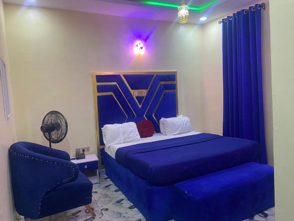 a bedroom with a blue bed and a blue chair at Bluespring luxury hotel in Elu