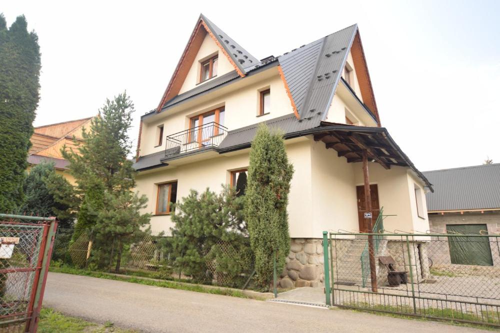 a large white house with a metal roof at Pokoje Gościnne Brynkus in Białka Tatrzańska