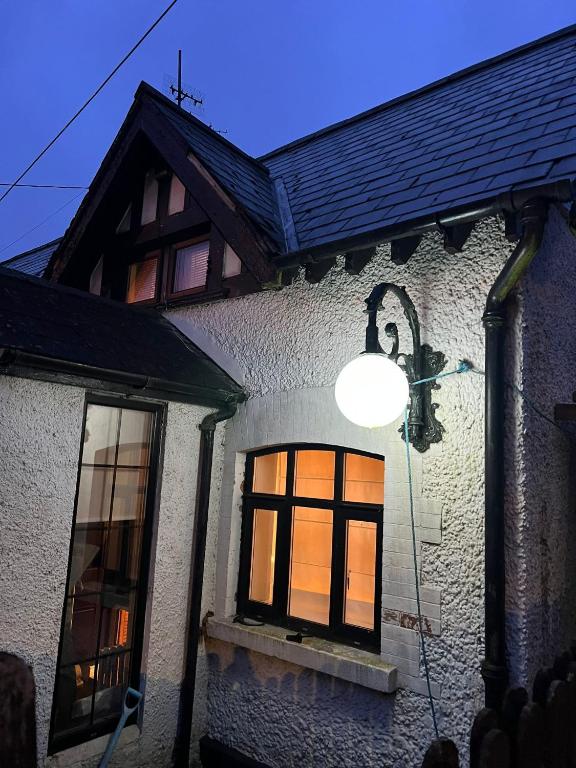 a house with a light in the window at Kilpedder cottage in Kilpedder