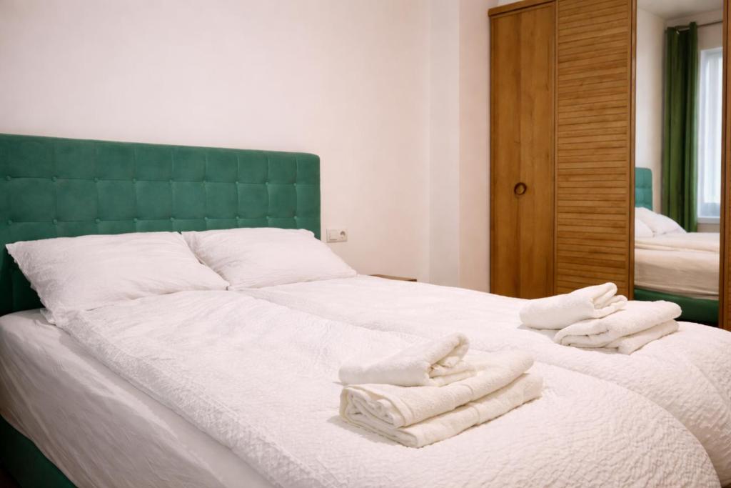 a bedroom with a bed with towels on it at Casa Centrale with Free Parking in Plovdiv