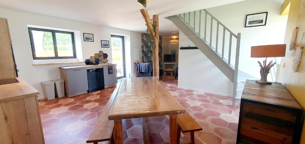 a kitchen with a wooden table in the middle of a room at la petite roche in Lanildut