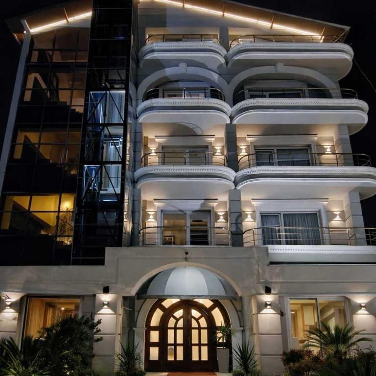 a large white building at night with its lights on at Broadway Boutique Hotel in Tirana