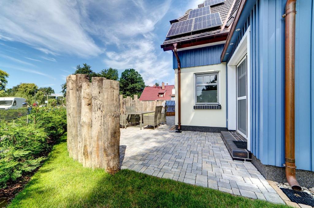 a blue and white house with a tree stump at Strandvej in Prerow