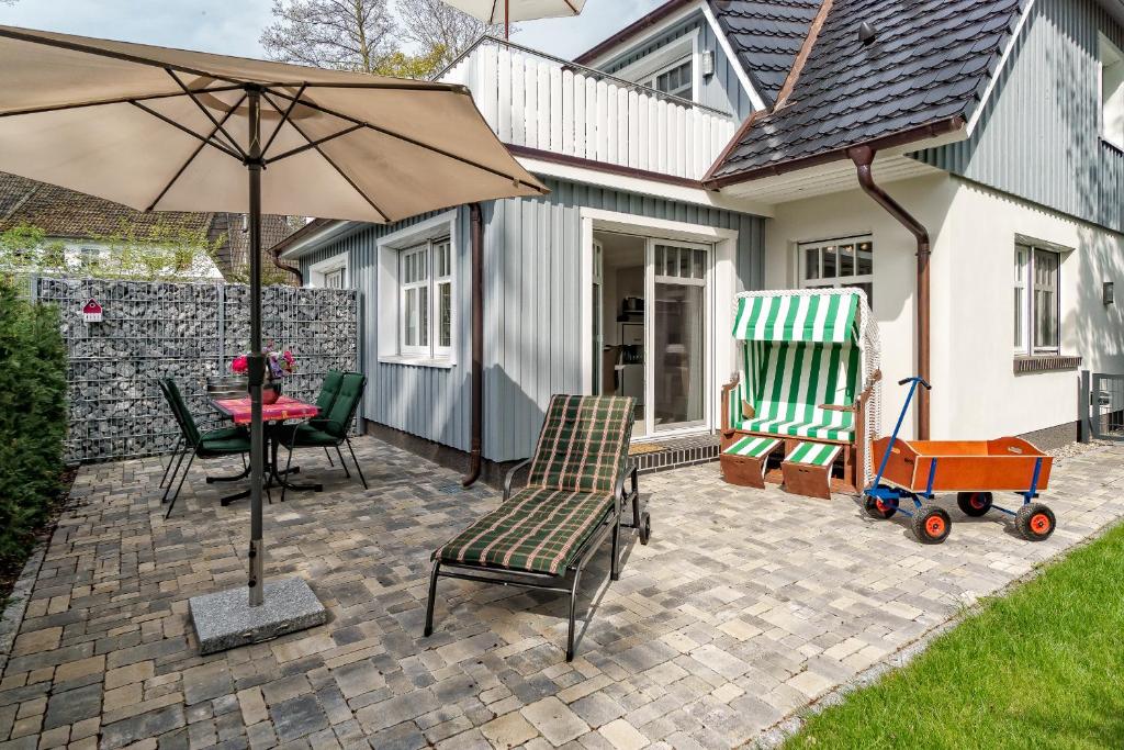 a patio with a table and chairs and an umbrella at Deichblick in Prerow