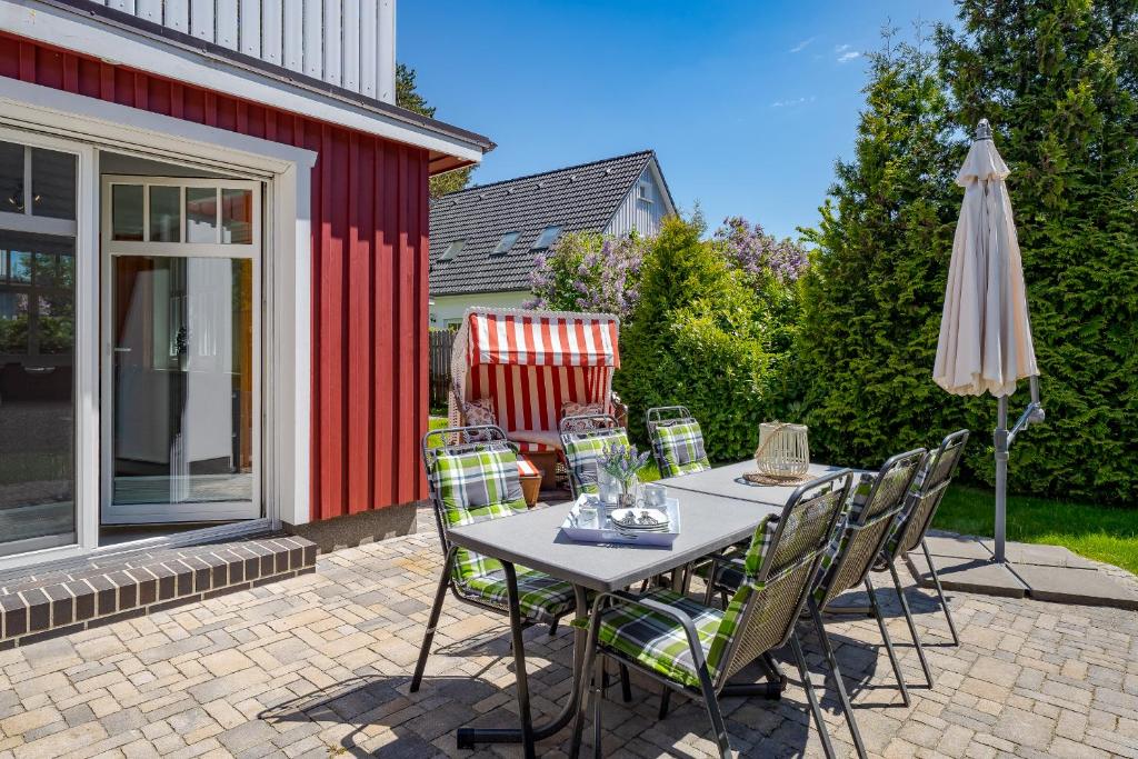 a table with chairs and an umbrella on a patio at Dreimäderlhaus in Prerow