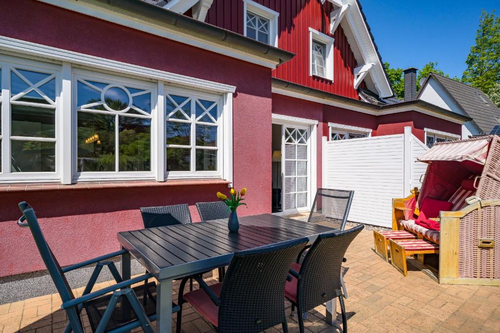 a patio with a table and chairs in front of a house at Min Leefste in Prerow