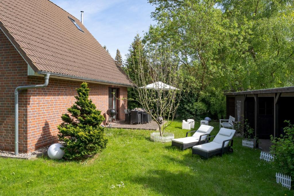 a yard with two chairs and an umbrella at Emma in Prerow
