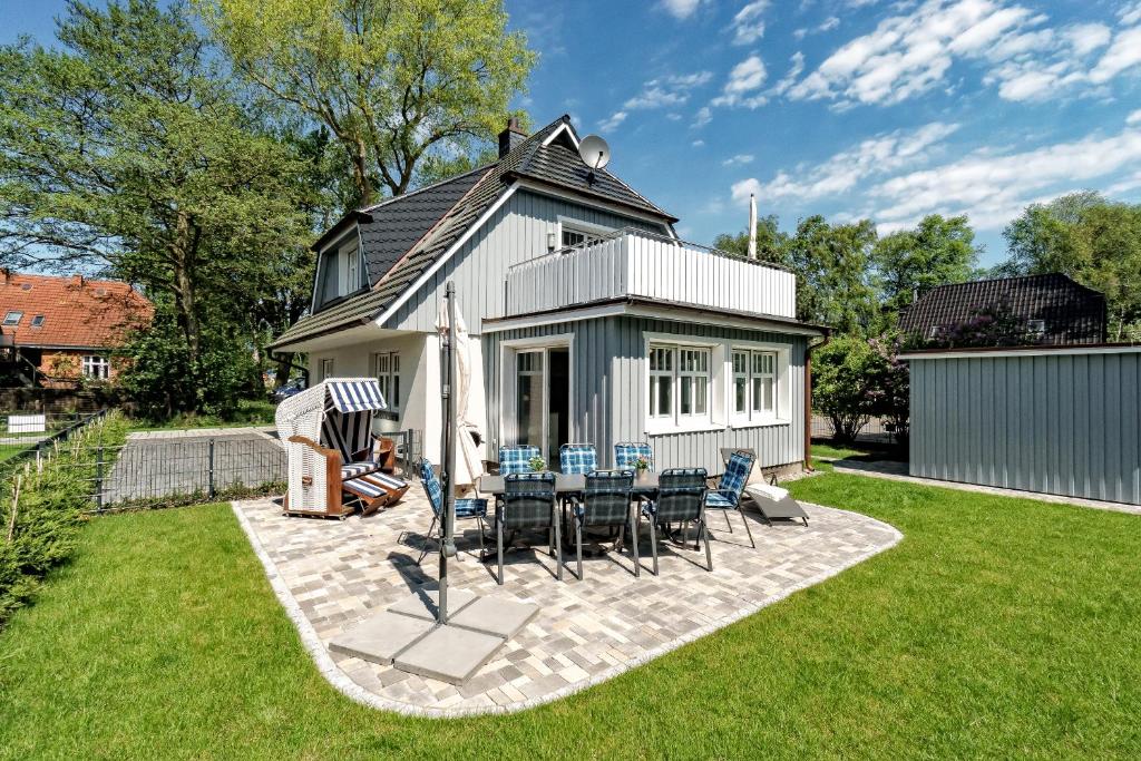 a house with a table and chairs in the yard at Stine in Prerow
