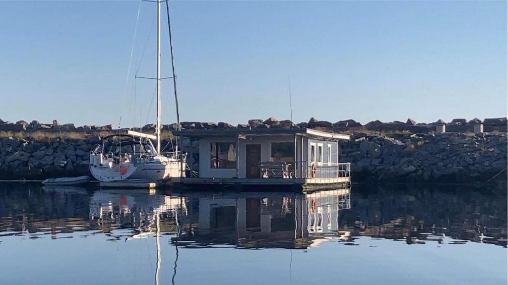 a small boat sitting in a body of water at Sætervika Floating home in Hosen