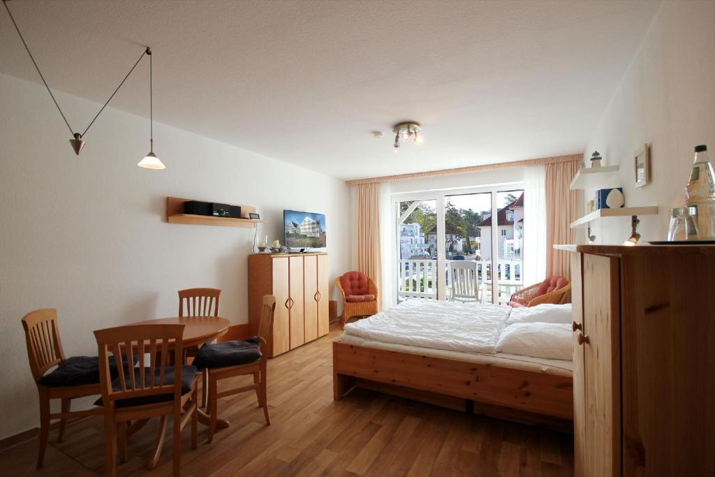 a bedroom with a bed and a table and a window at Haus Ostseeluft, Whg 4 Hühnergott in Baabe