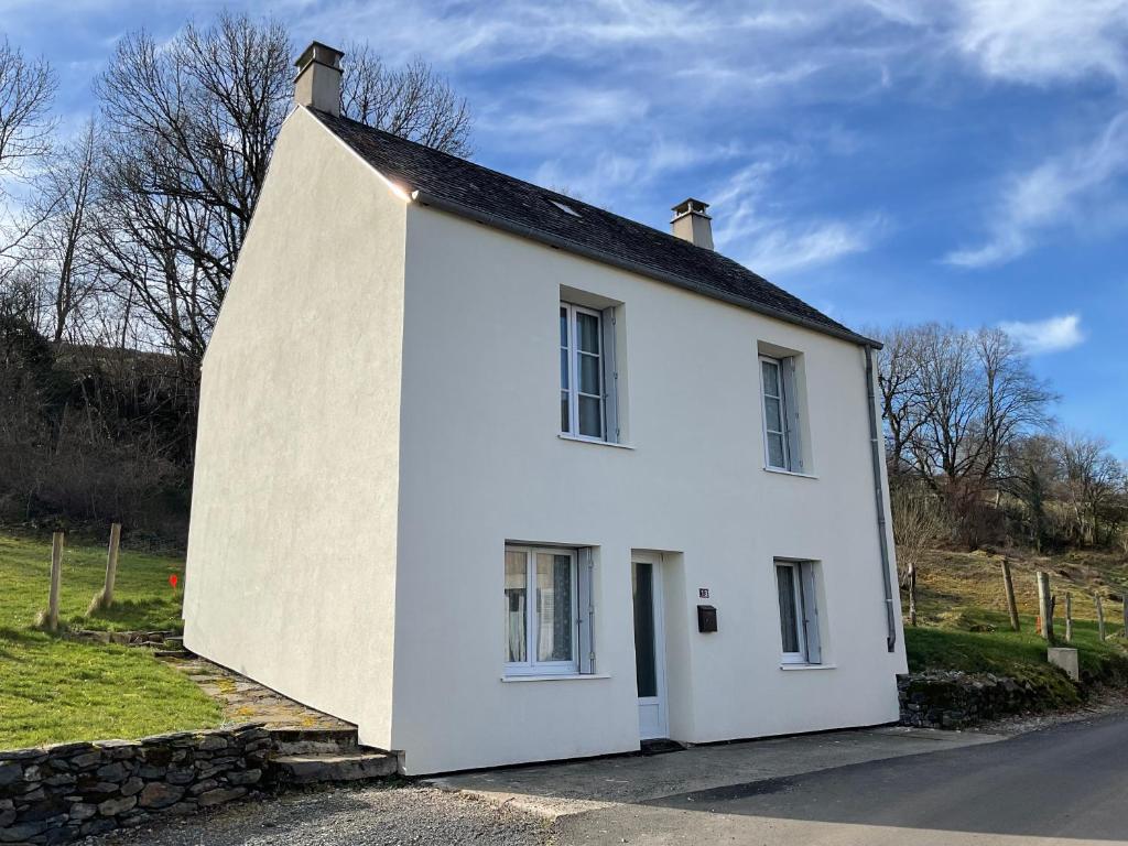 a white house on the side of a road at Maison 6 couchages in Le Monteil