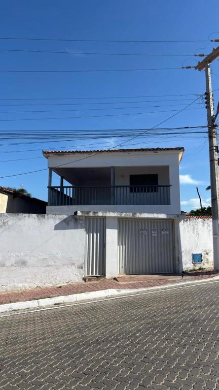 ein weißes Haus an einer Straßenseite in der Unterkunft CasaMajorlândia in Aracati