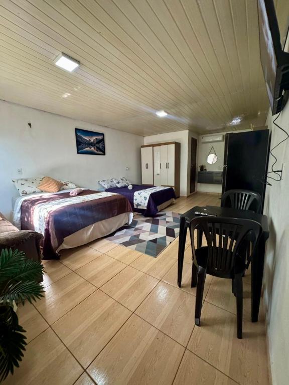 a bedroom with two beds and a table in a room at Suíte Conforto in Santarém