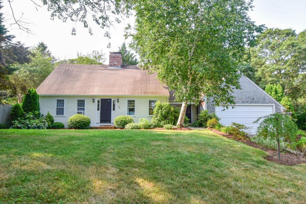 a white house with a tree and a yard at Less than 5 Miles to Rock Harbor in Orleans