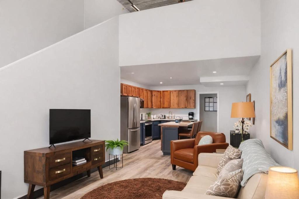 a living room with a couch and a tv at Charming Appleton Condo Downtown Modern Loft in Appleton
