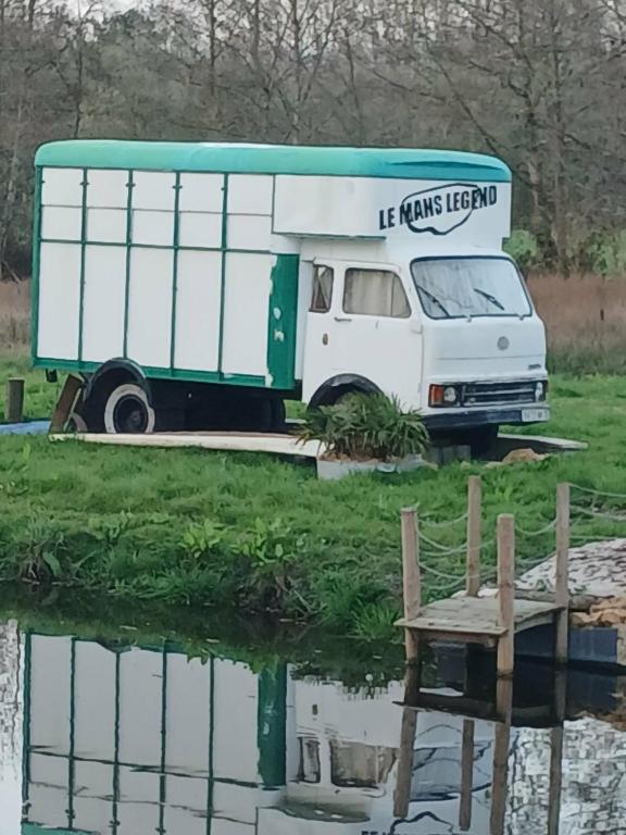 a food truck parked next to a pond at Nuit insolite in Beaufay