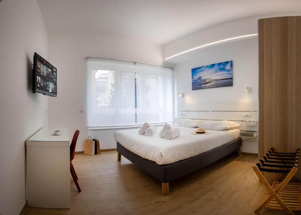 a bedroom with a bed and a desk and a window at RomeCookSea Guest House in Lido di Ostia