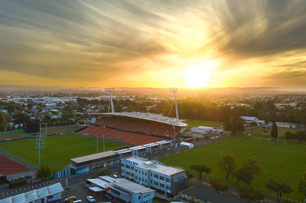 a stadium with a soccer field in front of the sunset at Hamilton Motel in Hamilton