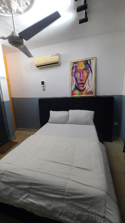 a bedroom with a bed with a ceiling fan at Exodus Hotel & Restaurant in Aiyetoro