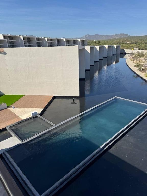 a pool of water on the roof of a building at New Golf Course Condo with Ocean Views in San José del Cabo
