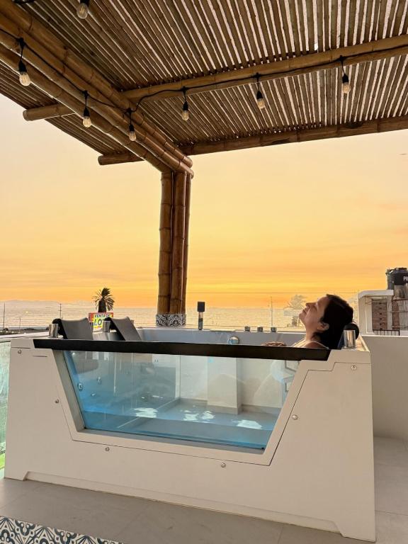 a hot tub on the roof of a building with the ocean in the background at Ballestas Suite in Pisco