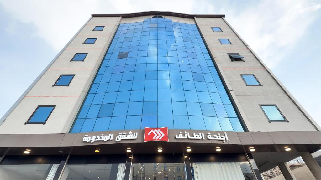 a tall building with a sign on it at اجنحة الطائف للشقق المخدومة - AL Taif Suites in Taif