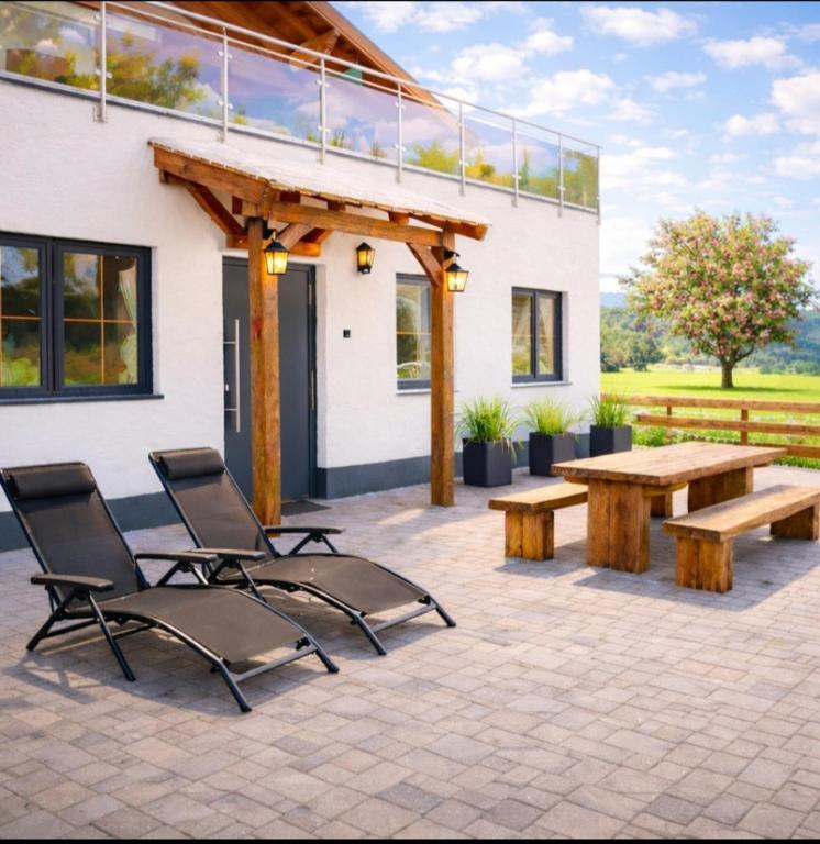 a patio with a wooden picnic table and chairs at Chalet Woidzauber in Zwiesel