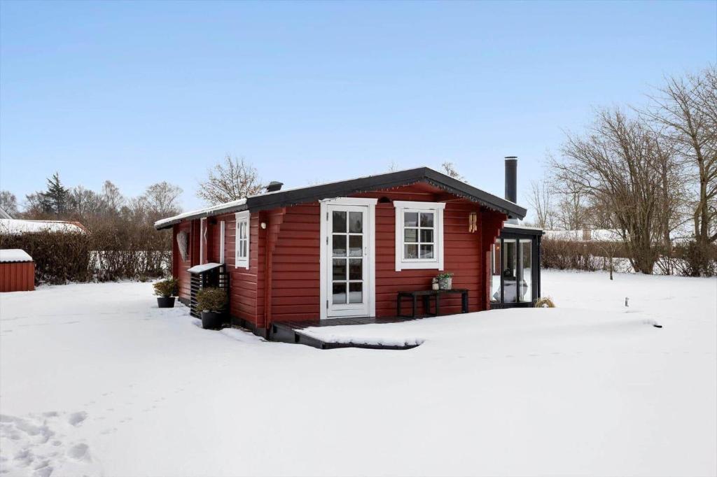 a red tiny house in the snow at LL269-Tranekaer-Rollikevej-20-a in Stoense