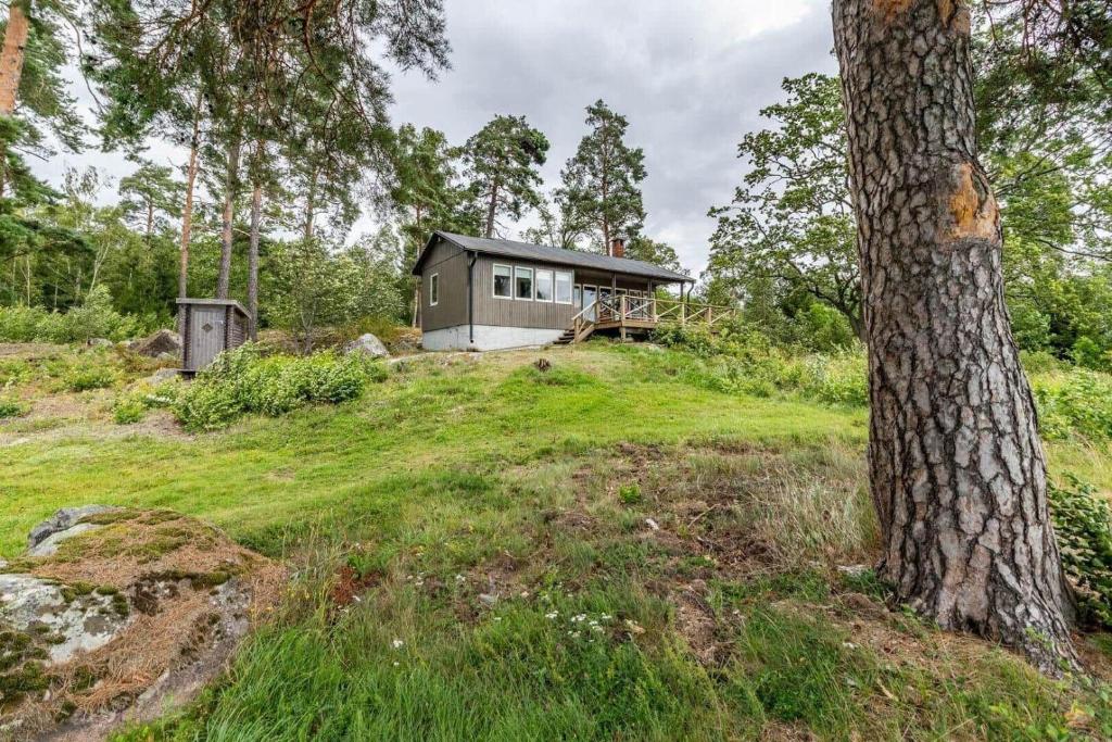 a house on a hill with a tree at VMA945-Koeping-Avhulta-Gard-1 in Köping