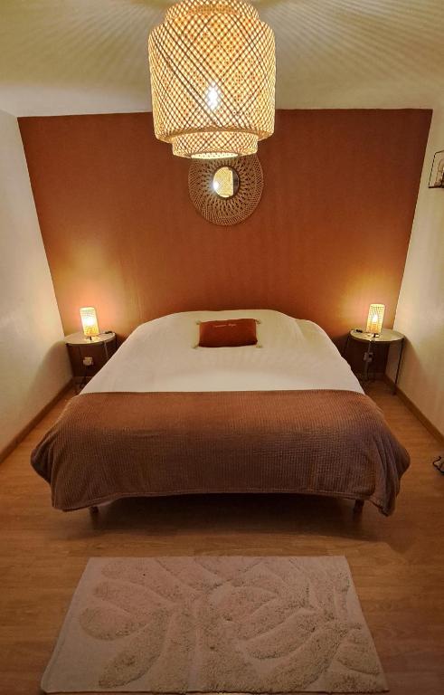 a bedroom with a large bed and a chandelier at Cocoon Spa in Issenheim