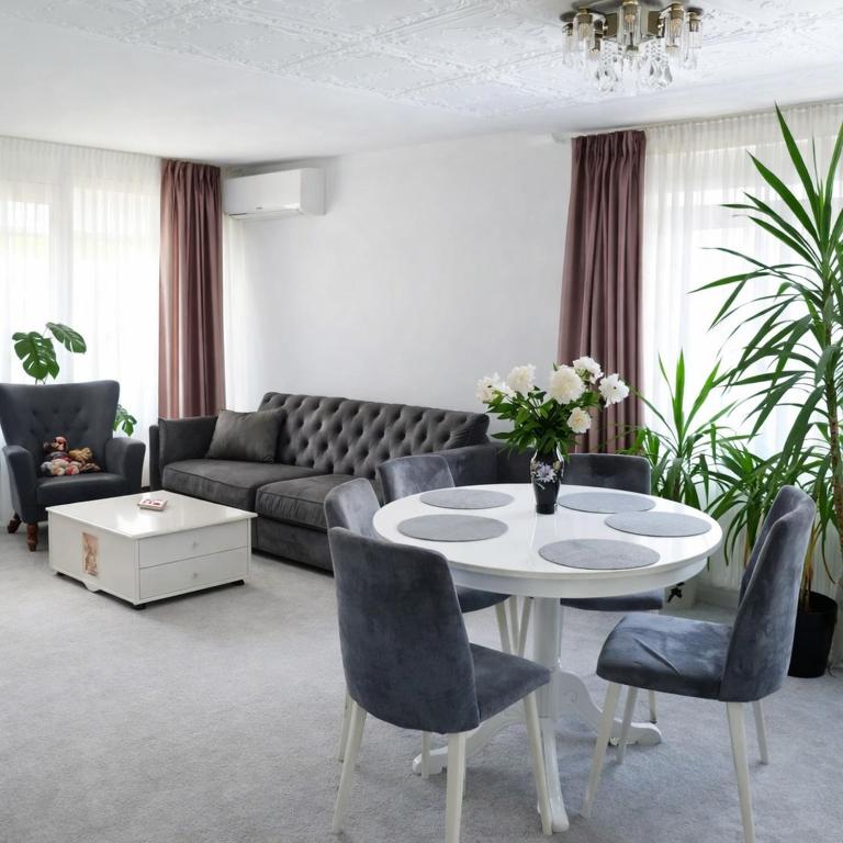 a living room with a couch and a table and chairs at Căsuța galbenă in Bucharest