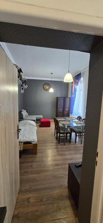 a living room with a bed and a dining room at Apartament w Centrum Ząbkowic Śląskich z Dwoma Sypialniami in Ząbkowice Śląskie