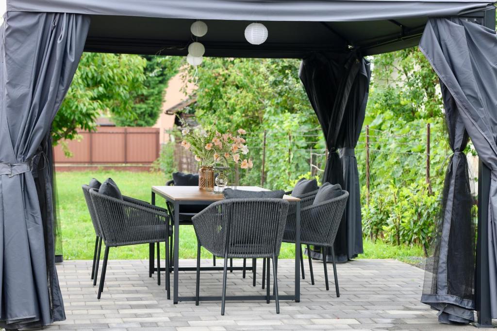 a black gazebo with chairs and a table at Wolf House in Balatonboglár