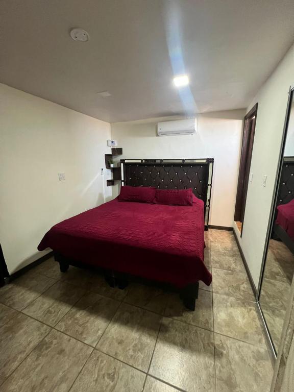 a bedroom with a bed with a red bedspread at Chocolate condo in San Felipe